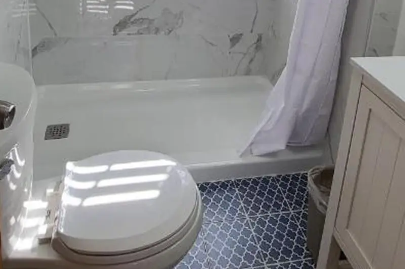 A soaking tub and vanity in a bathroom finished in white marble-look tile