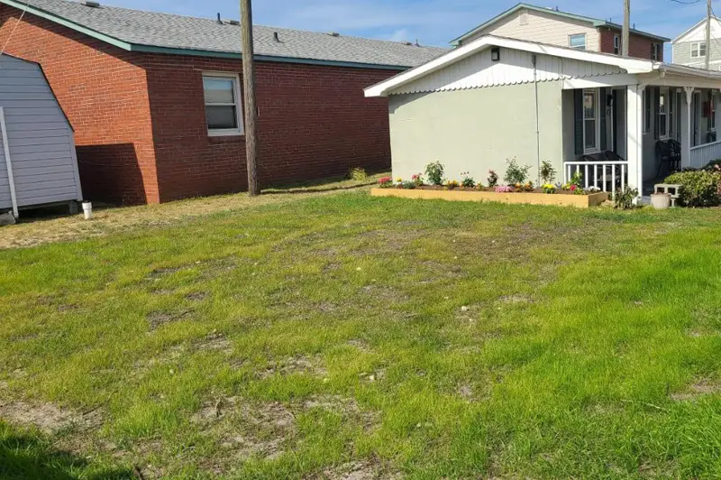 The motel's red-brick building and covered porch, seen from the lawn next door