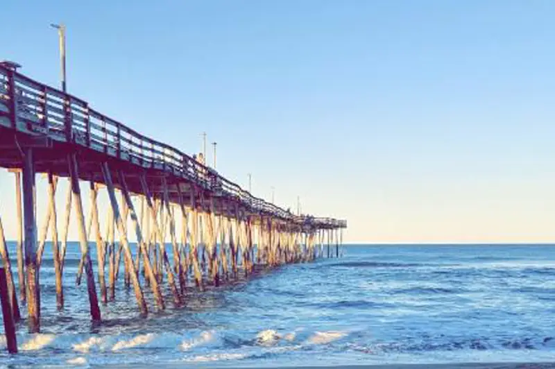 A fishing pier reaching out over the Atlantic Ocean at dusk